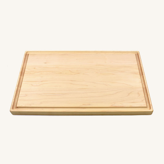 Tabla de cortar de madera gruesa con bordes redondeados y ranura para jugo